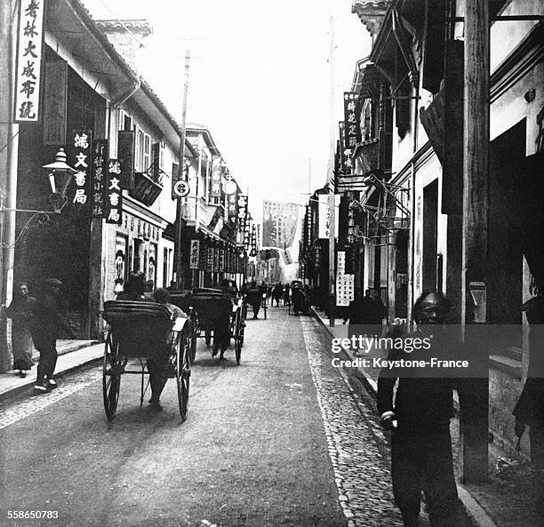 Vue d'une rue commerçante de la ville, à Shanghai, Chine, circa 1910.