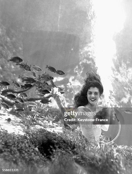 Jeune fille posant sous l'eau dans le théâtre sous-marin de la ville, à Weeeki Wachee, Floride.