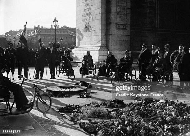 Les militaires raniment la flamme de la tombe du soldat inconnu à Paris, France le 14 juillet 1930.