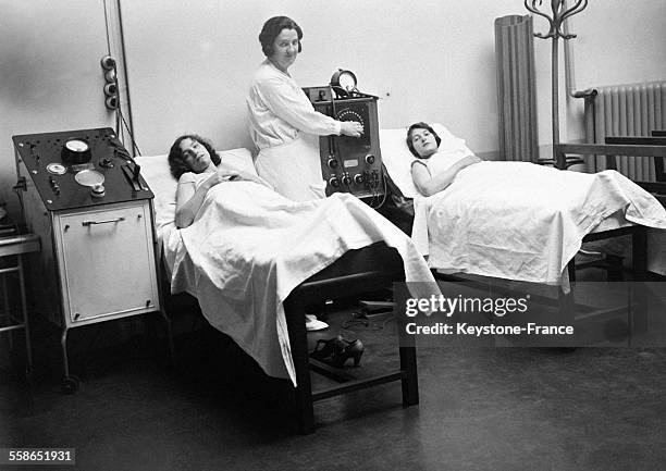 Deux Parisiennes allongées sur des lits pour un examen médical gratuit à l'Institut à Paris, France le 21 juillet 1930.