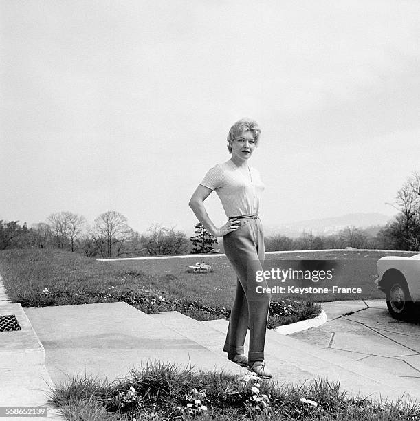 La chanteuse de music-hall francaise Line Renaud devant sa maison en 1960, a La Celle-Saint-Cloud, France.