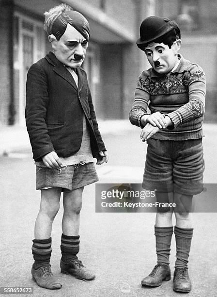 Enfants portant des masques représentant Adolf Hitler et Charlie Chaplin afin d'en comparer la moustache, à Londres, Royaume-Uni.