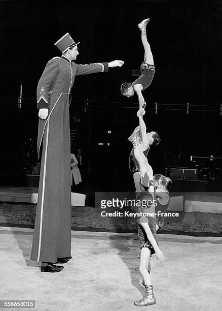 Numéro d'acrobatie des 'Schafer's Midgets', troupe d'hommes et de femmes de très petite taille, face à un homme sur des échasses, au Bertram Mills...