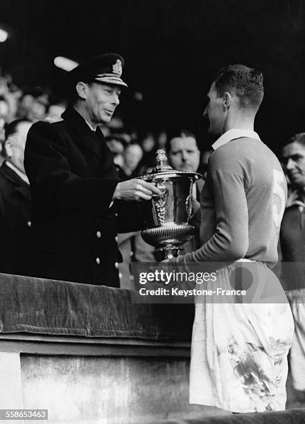 Le roi George VI remet la coupe au capitaine Harris de l'equipe de Chelsea, le 7 avril 1945 a Londres, Royaume-Uni.