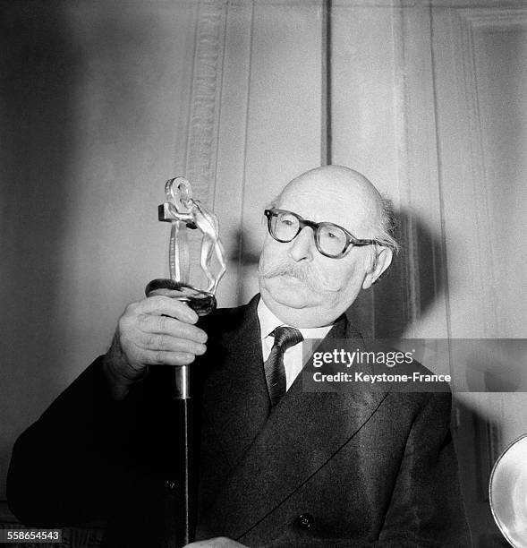 Jean Rostand tenant l'épée d'académicien qui comporte une grenouille, à Paris, France le 9 novembre 1959.