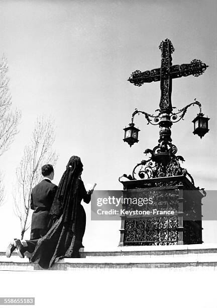 Avant que commence la procession du Vendredi Saint, un jeune couple marié dans l'année fait une prière devant un ancien crucifix, à Madrid, Espagne