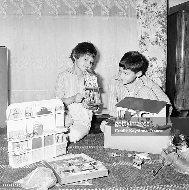 Enfants ouvrant leurs cadeaux la nuit de Noël, en France le 25 décembre 1959.