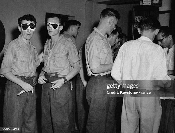 Départ des blessés de Diên Biên Phuphotographiés à l'aéroport de Saigon faisant leurs courses avant leur départ pour la France, à Saigon, Indochine...