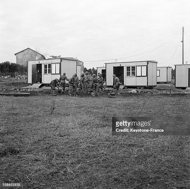 Les soldats travaillent aux travaux de finitions de l'installation des maisons préfabriquées, à Fréjus, France le 17 décembre 1959.