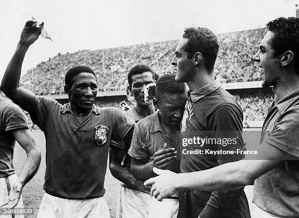 Les footballeurs brésiliens Djalma Santos, Pelé et Gilmar pleurent de joie après leur victoire contre la Suède lors de la finale de la coupe du monde...