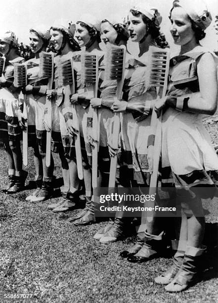Ces gentilles ecolieres armees d'enormes brosses a dents, font des exercices de culture physique au cours d'une 'fete de l'hygiene' organisee par un...