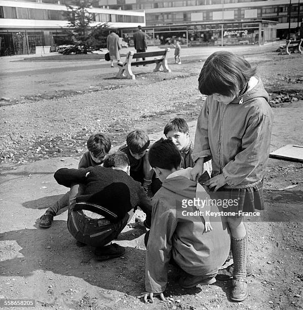 Enfant accrochant à dos de son camarade un poisson d'avril, à Paris, France le 1 avril 1960.