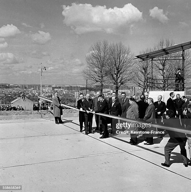 Le ministre des Travaux Publics et des Transports Robert Buron coupant le ruban officiel pendant l'inauguration de l'autoroute du Sud, à Paris,...