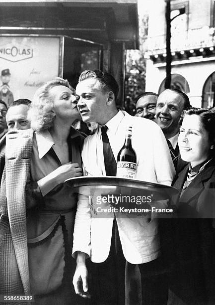 Le vainqueur de la course de garçons de café est félicité par une jolie jeune femme, à Paris, France le 18 mai 1952.