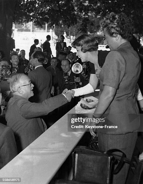 Le Président de la République Française Vincent Auriol serre la main de la comédienne Suzy Delair lors de la kermesse aux étoiles au profit des...