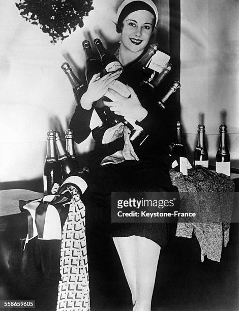 Jeune femme tenant des bouteilles de champagne qui contiennent des cravates, bijoux et autre cadeaux, idée de cadeaux de Noël d'un grand magasin...