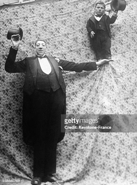 Le jeune marié géant de 2, 70 m portant dans sa main une personne de toute petite taille, à Turin, Italie, le 2 février 1931.