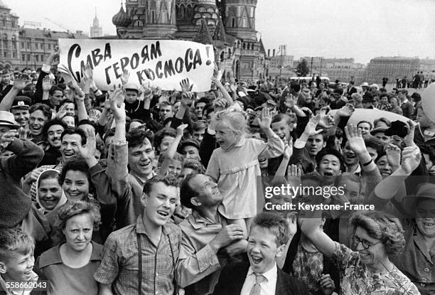 Sur la Place Rouge, la foule fête avec enthousiasme l'annonce de l'agence de presse TASS du succès du lancement de la fusée Vostok-6 dans laquelle se...