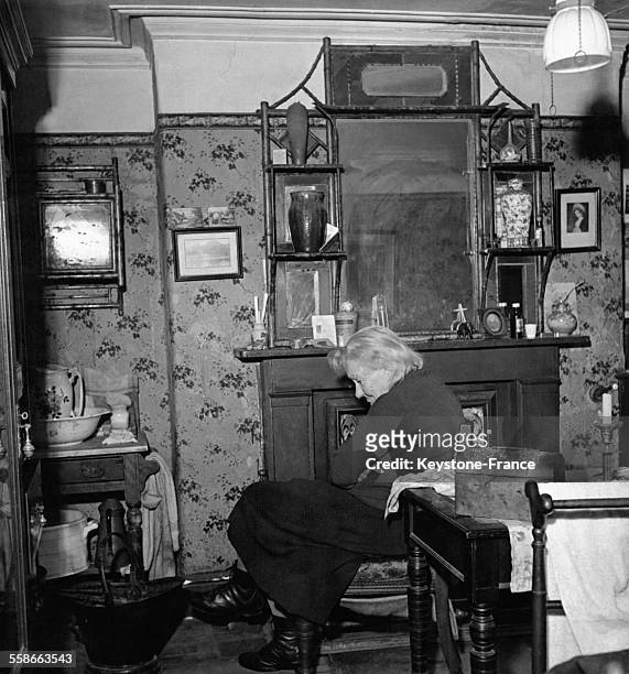 Miss Constance Needell, vieille dame seule, chez elle dans un appartement en sous-sol à l'équipement rudimentaire, à Croydon, Royaume-Uni.