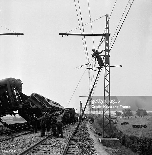 Les équipes d'ouvriers occupés à remettre les voies en état après le déraillement d'un train qui a causé la mort de cinq personnes et trente blessés,...