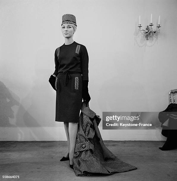 Collection Automne-Hiver 1962 : Ligne "Croissant de Lune". Manteau en lainage à carreaux blanc et noir "RUE LEPIC". Robe noire avec rappel de...