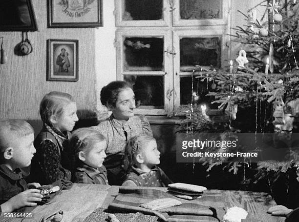 Une famille de Bavière réunie autour du sapin de Noël chante les chansons traditionnelles de Bavière, en Allemagne.