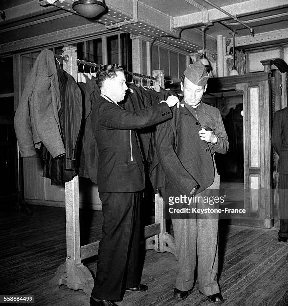 Des prisonniers libérés habillés au rayon vêtement de la Samaritaine, à Paris, France en 1945.