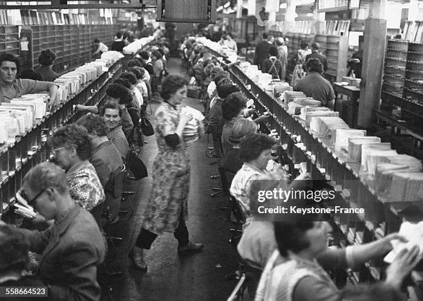 L'approche de Noël et l'envoi des cartes de voeux, l'activité est à son maximum dans ce tri postal en Allemagne en décembre 1960.