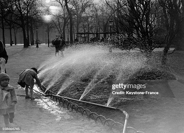 Arrosage des fleurs sur les Champs-Elysées à Paris, France le 25 avril 1931.