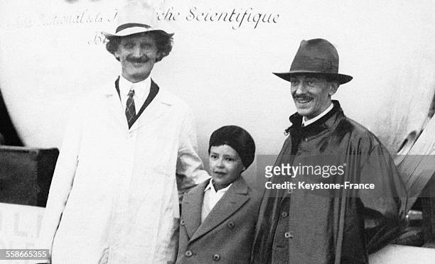 Le Professeur Auguste Piccard et son assistant le docteur Max Cosyns et son jeune fils posent devant la sphère qui tient lieu d'habitacle au ballon...