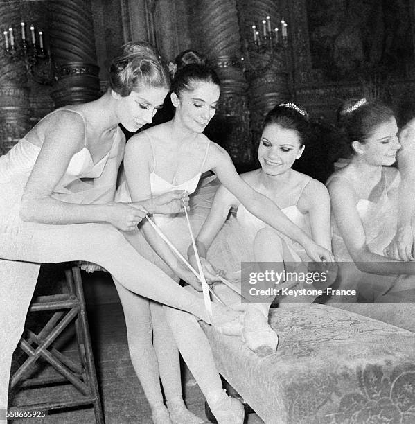 Danseuses nouant leurs chaussons avant leur passage sur scène, à Paris, France le 1 avril 1967.