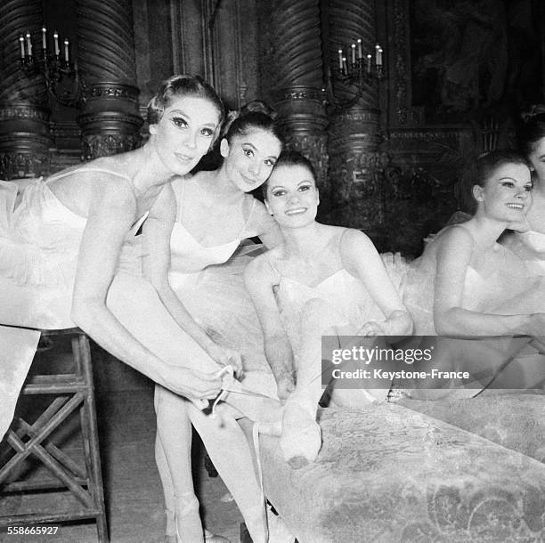 Danseuses nouant leurs chaussons avant leur passage sur scène, à Paris, France le 1 avril 1967.