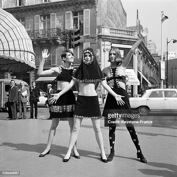 Mini-jupe à bretelle, cagoule et mini-jupe et mini-jupe et cache-coeur en velours, posant Faubourg Saint-Honoré à Paris, France le 17 avril 1967.