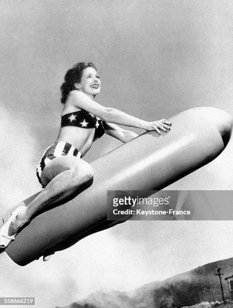 Actrice Ann Gwynne assise sur une bombe atomique, aux Etats-Unis en 1945.
