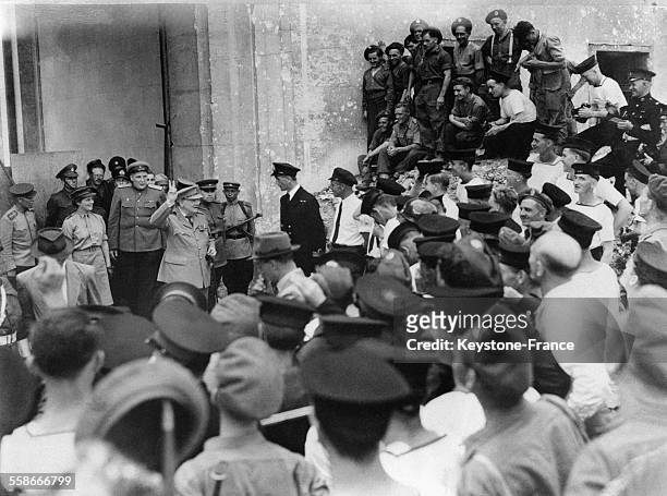 Winston Churchill dans les ruines de la ville faisant le signe V de la victoire à ses marins, à ses côtés sa fille Mary, à Berlin, Allemagne en 1945.