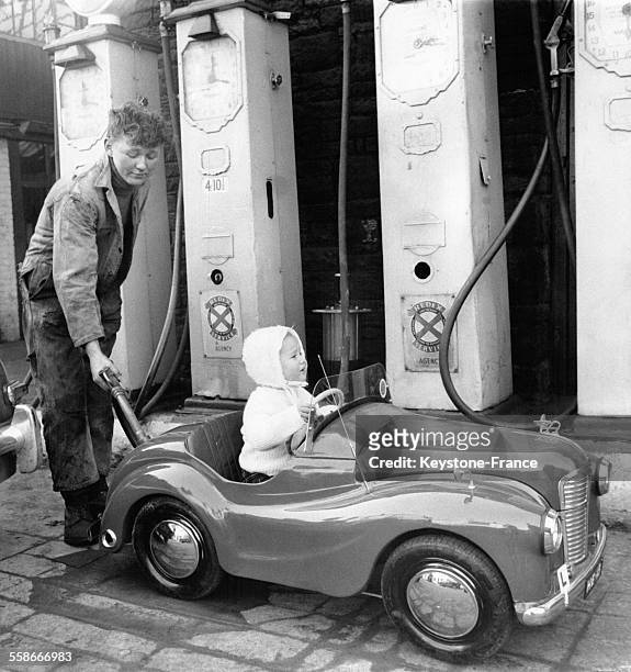 Fiona Egglestone, âgée de 18 mois, fait le plein de sa petite voiture au garage de son père, un mécanicien qui a conçu une voiture miniature adaptée...