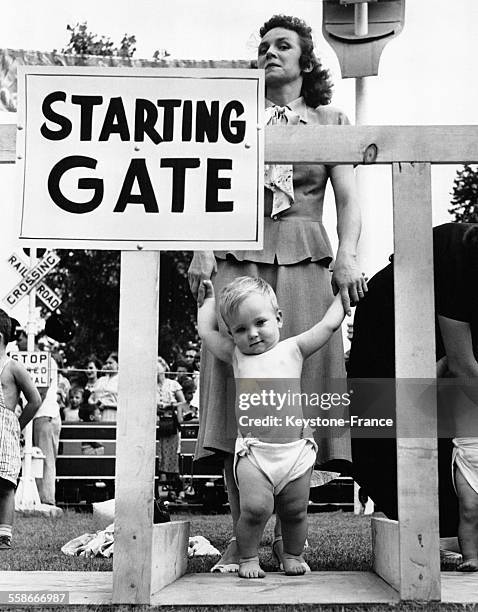 Une mère tient les mains de son bébé dans les starting-blocks pour la course de bébés, ou 'Diaper Derby' de Palisades Park, dans le New Jersey, NJ.