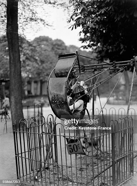 Un petit garçon sur une balançoire dans un square près des Champs-Elysées, circa 1930 à Paris, France.