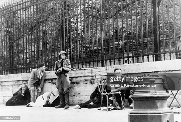 Des FFI planqués contre le mur du Jardin des Tuileries affrontent les soldats allemands dans les rues de Paris, France le 10 août 1944.