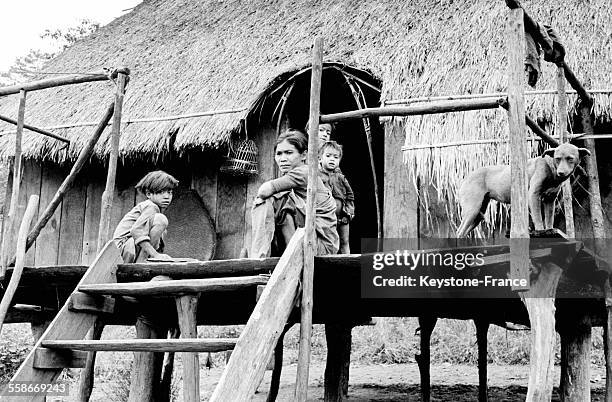 Mère et enfants sur la terrasse d'une maison sur pilotis à Saigon, Vietnam en juillet 1959.