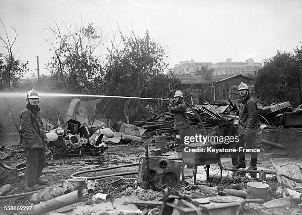 Pompier éteignant un incendie qui a détruit 13 maisons en bois dans le XIIIème arrondissement, à Paris, France, le 16 juillet 1931.