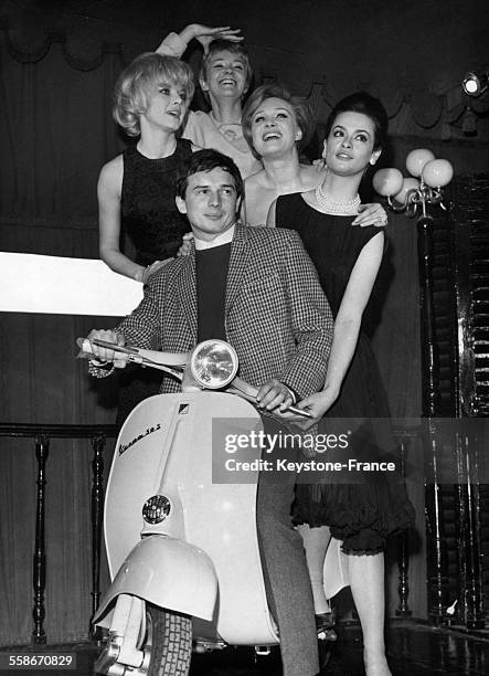 Le pilote automobile Jean-Pierre Beltoise, entouré de Sophie Hardy, Claudine Coppin, Danik Patisson et Marie Versini, sur la nouvelle Vespa 50 S au...