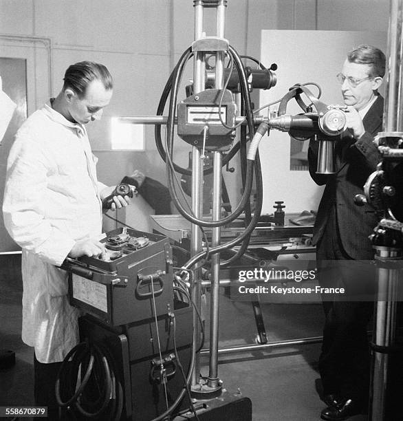 Appareil de radiologie ultra moderne et deux médecins en étudient le fonctionnement, à l'Hopital Beaujon à Paris, France le 16 novembre 1945.