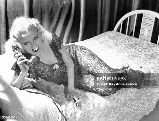 La danseuse de cabaret américaine Jo Ann Carroll en conversation au téléphone allonge sur un lit à Broadway, à New York City, NY.