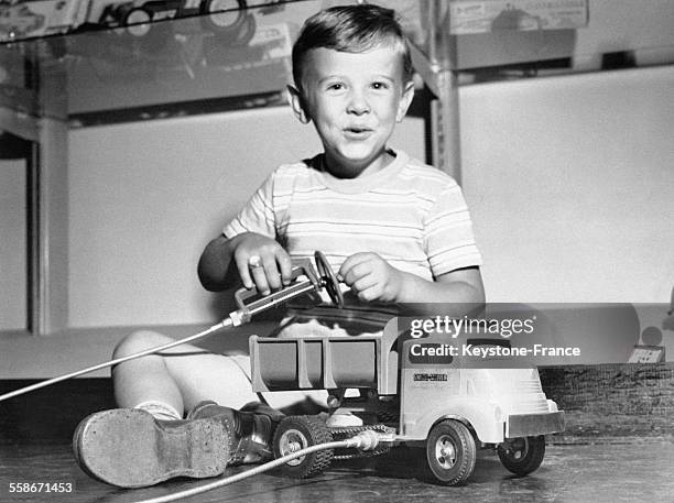 Un petit garçon est enthousiasmé par son nouveau jouet, un camion qu'il a reçu au salon de l'enfance et du jouet le 7 juillet 1949 à New York City,...