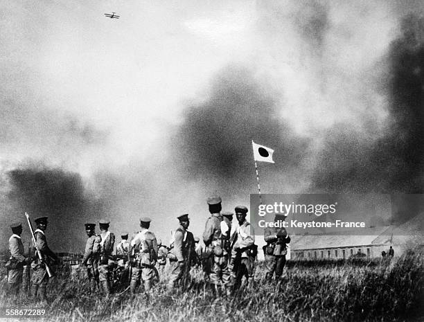 Les soldats japonais après l'occupation des casernes chinoises, dans le ciel, un avion de bombardement japonais survole la région, en Chine le 21...