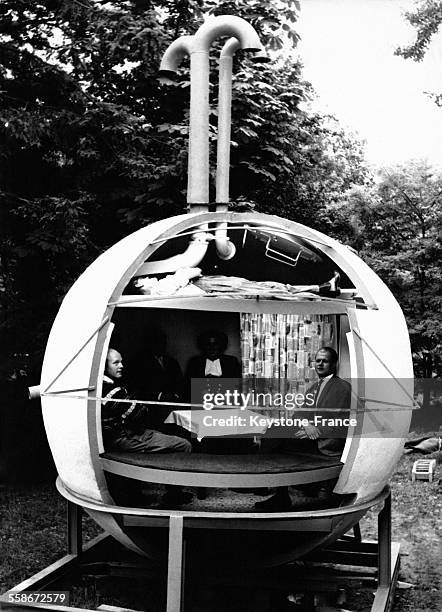 Des particuliers sont installés à l'intérieur d'un abri anti-atomique en forme de sphère de ciment dans leur jardin le 8 septembre 1962 à Hambourg,...