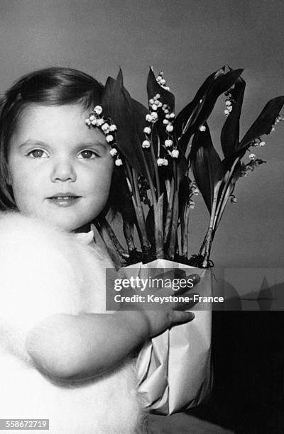 Une petite fille a acheté un bouquet de muguet le 26 avril 1958 en France.