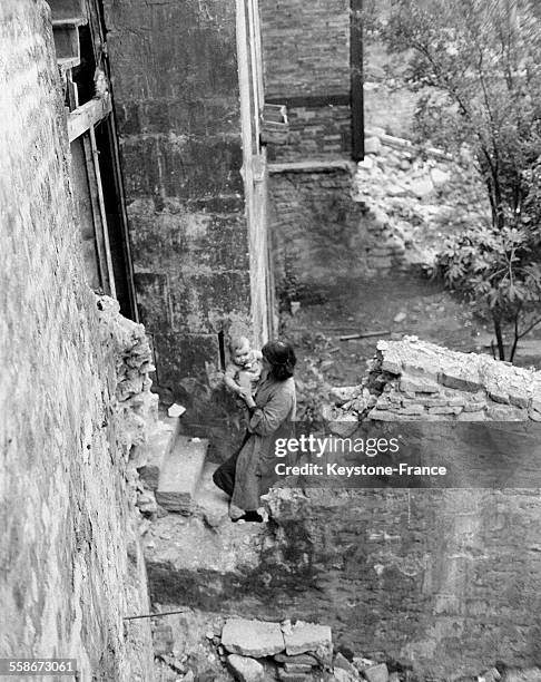 Dans la rue Haute, une famille de 4 personnes vit dans une pièce de 3x2m à laquelle on accède par un escalier en ruine, à Caen, France, circa 1940.