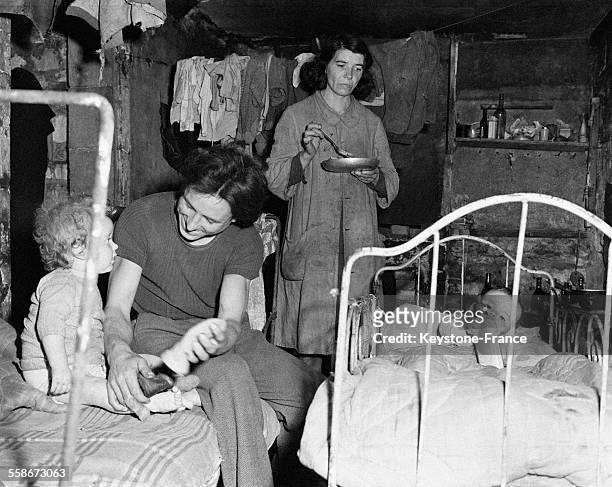 Dans la rue Haute, une famille de 4 personnes vit dans une pièce de 3x2m à laquelle on accède par un escalier en ruine, à Caen, France, circa 1940.